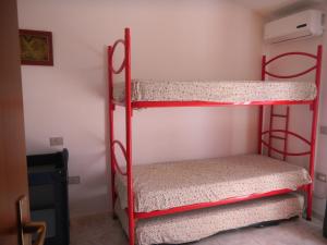 ヴィッラシミーウスにあるVilla Claudiaの壁付きの客室で、赤い二段ベッド2台が備わります。