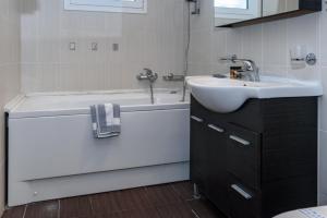 a bathroom with a sink and a bath tub and a sink at Agamemnon Hotel in Nafplio