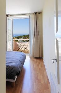 a bedroom with a bed and a view of a balcony at Picouveau in Cassis