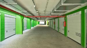 un corridoio vuoto in un edificio con porte verdi e bianche di Hotel Al Prater a Lignano Sabbiadoro