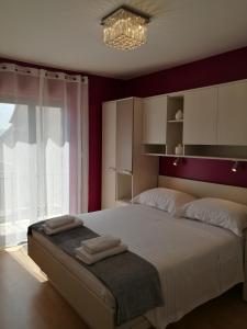 a bedroom with a large bed with towels on it at Apartments Benika in Bol