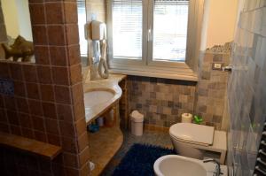 a bathroom with a sink and a toilet and a window at Forte House in Milan