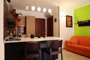 una cocina con una isla con sillas y un sofá naranja en Appartamento Giove, en Otranto