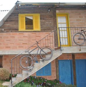 a bike hanging from a railing on a house at Hostel da Montanha in Campos do Jordão