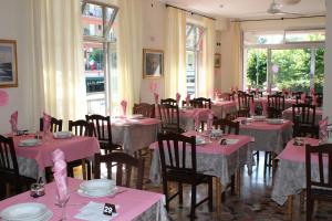 リミニにあるHotel Oblioのピンクのテーブルクロスが敷かれたテーブルと椅子が備わる部屋
