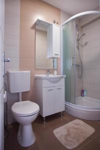 W łazience znajduje się toaleta, umywalka i prysznic. w obiekcie London Rooms Zagreb Airport w mieście Velika Gorica