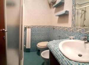 y baño con aseo blanco y lavamanos. en Appartamento Giove, en Otranto