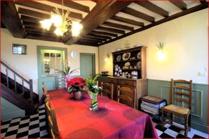 comedor con mesa y mantel rojo en le clos Sainte Helene, en Glos-sur-Risle