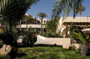 a resort with palm trees and a building at Dead Sea Spa Hotel in Sowayma