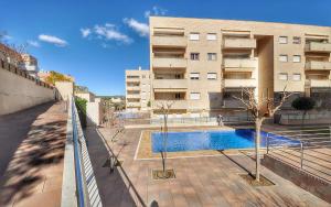 a building with a swimming pool in front of a building at Apartamento ADIA in Lloret de Mar