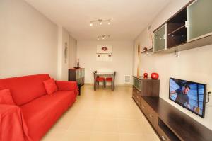 sala de estar con sofá rojo y mesa en Apartamento ADIA, en Lloret de Mar