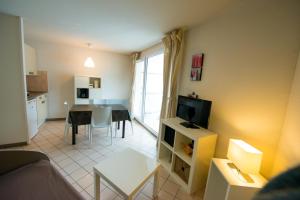 uma pequena sala de estar com uma mesa e uma cozinha em Terres de France - Résidence les Silènes em Allevard