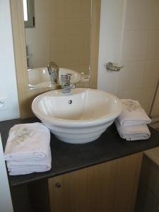 La salle de bains est pourvue d'un lavabo blanc et d'un miroir. dans l'établissement Résidence Goélia Aquaresort, à Nérac