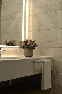 a bathroom with a vase with flowers on a sink at Holiday Inn Bursa - City Centre by IHG in Bursa