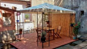 a patio with a table and chairs and an umbrella at Casa "Le tre Muse" in Deruta
