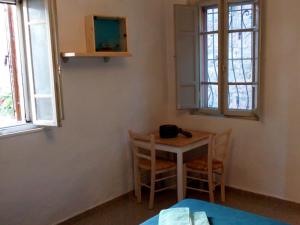 a small table and chairs in a room with windows at Casa "Le tre Muse" in Deruta
