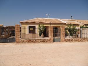 a brick building with a gate and a fence at Casa Rural Villa Lucia in Ossa de Montiel