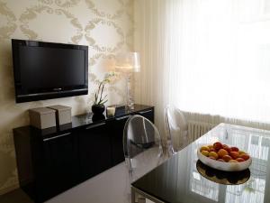a living room with a television and a bowl of fruit on a table at VISIONAPARTMENTS Waffenplatzstrasse - contactless check-in in Zürich