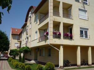 an apartment building with flowers on the balconies at Lux Apartmanok in Hajdúszoboszló