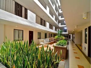 a hallway of a building with plants and tables and chairs at Angels Nest in Camella Northpoint Condominium Studio & 2 bedrooms Unit in Davao City