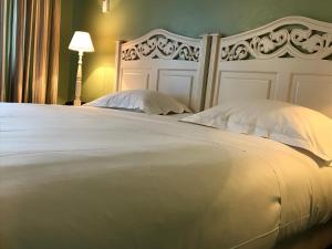 a bed with a white bedspread and pillows at Hotel Le Festival in Cannes