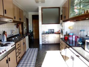 a kitchen with a sink and a stove top oven at Casa do Sol in Porto
