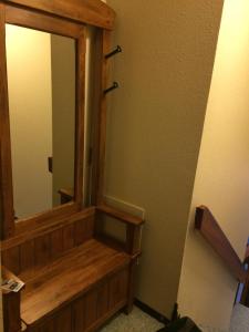 a bathroom with a mirror and a wooden bench at Mountain Edge our Holiday Home in Kimberley