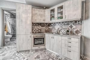 a kitchen with white cabinets and a fireplace at Eos Aurora Suite in Corfu