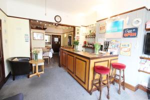 a bar in a restaurant with two stools and a counter at Maluth Lodge in Great Yarmouth