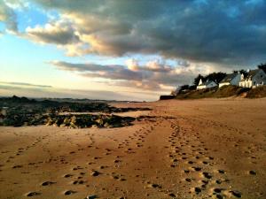 a sandy beach with footprints in the sand at Location 44410 in Saint-Lyphard