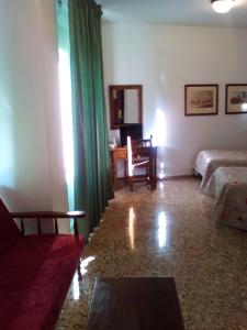 Sala de estar con 2 camas y mesa en Hotel Andalucía en Cazorla