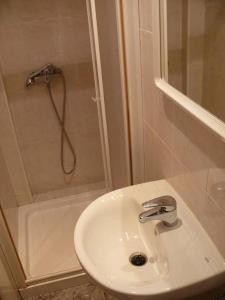 een witte badkamer met een wastafel en een douche bij Hostal Rodes in Mequinenza