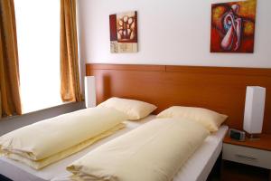 2 almohadas en una cama en un dormitorio en Hotel Evido Salzburg City Center, en Salzburgo