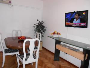 a dining room with a table and a tv on a wall at Suipacha Obelisco Departamento Familiar in Buenos Aires