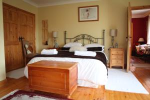 a bedroom with a large bed with a wooden table at Newlands Lodge in Kilkenny