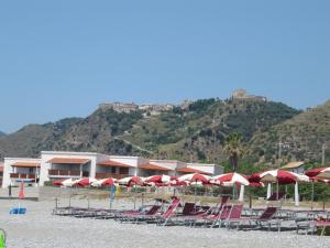 a bunch of chairs and umbrellas on a beach at Residenza d'Epoca Borgodifiume in Fiumefreddo Bruzio