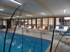 a pool in a room with chairs and tables at COMPLEX TURISTIC CASIANNA & Spa in Păltiniş