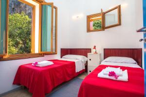 サン・ヴィート・ロ・カーポにあるVilla Firriatoの赤と白のシーツが備わる客室のベッド2台