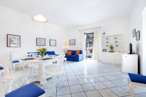 een witte woonkamer met een witte tafel en stoelen bij Appartamento Cassano Blu in Piano di Sorrento