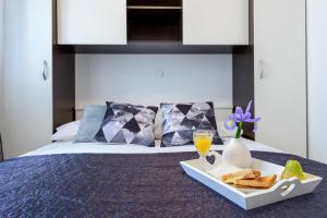 bandeja con pan y bebida y bandeja de comida en la cama en Lorelai Apartments en Dubrovnik