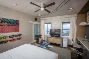 Schlafzimmer mit einem Bett und einem Flachbild-TV in der Unterkunft La Casa Del Camino in Laguna Beach
