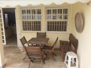 a wooden table and chairs on a patio at Casa Praia p/ 13 Pessoas c/ piscina - Cibratel 2 in Itanhaém