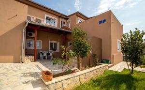 a house with a patio in front of it at Apartments Zara in Petrcane
