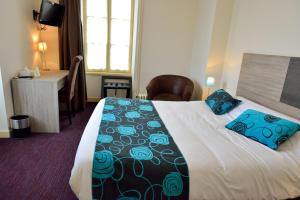 a hotel room with a bed and a desk at Logis Hostellerie de l'Abbaye in Celles-sur-Belle