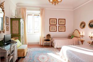 1 dormitorio con 2 camas, TV y ventana en Relais Cavalcanti Guest House, en Florencia
