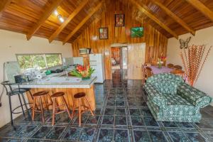 cocina y sala de estar con barra y sillas en Cabañas Valle Campanas - Monteverde, Costa Rica, en Monteverde