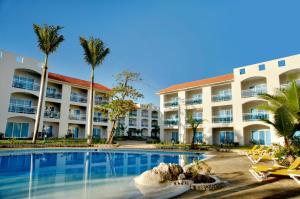 um resort com piscina e palmeiras em Cofresi Palm Beach & Spa Resort - All Inclusive em San Felipe de Puerto Plata