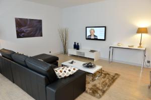 a living room with a black couch and a table at Logis Hostellerie de l'Abbaye in Celles-sur-Belle