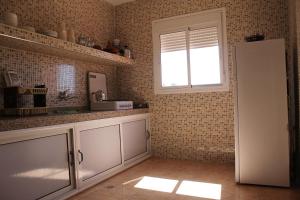 a kitchen with a white refrigerator and a window at Appart'hotel Dior Lamane in Azilal