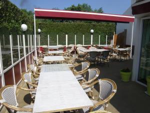 una fila di tavoli e sedie su un patio di Dolce Vita a Bruay-la-Buissiere